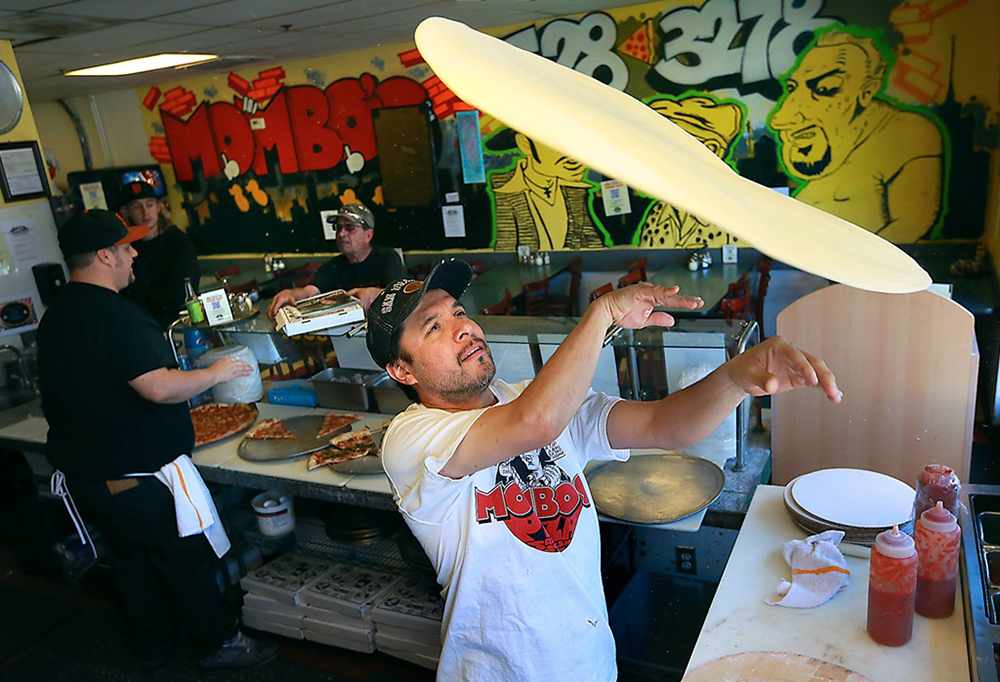 Man throwing pizza dough in Mombo's restaurant